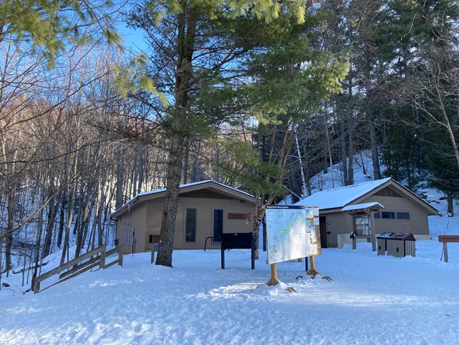 Munising Falls Visitor Center and restroom buildings in snowy winter scene