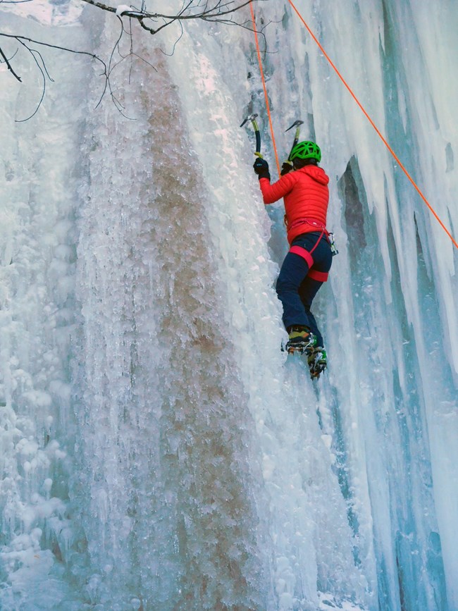 Ice climber ascending ice curtain