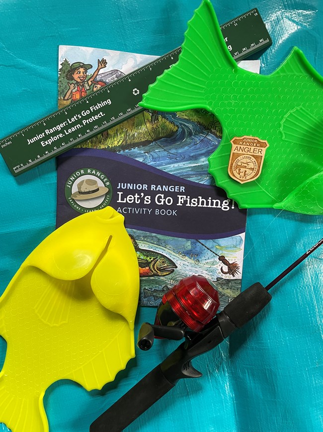 Junior Ranger Angler booklet, fishing pole, fish ruler, fish toys, and junior ranger badge