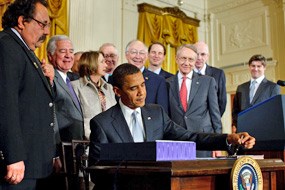 President Obama signs the Omnibus Public Lands Management Act of 2009 into law on March 30 at the White House. Also pictured from left to right: Rep. Raúl Grijalva (D-AZ), Rep. Nick Rahall (D-WV), Speaker of the House Nancy Pelosi (D-CA), Rep. Buck McKeon (R-CA), Secretary of the Interior Ken Salazar, Senate Majority Leader Harry Reid (D-NV), Senator Ron Wyden (D-OR), and Senator Robert Bennett (R-UT) (White House Photo, 3/30/09, Chuck Kennedy)