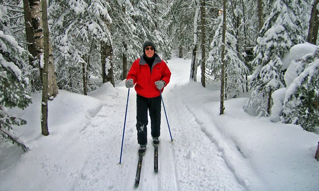 Skier in bright red jacket surrounded by snow