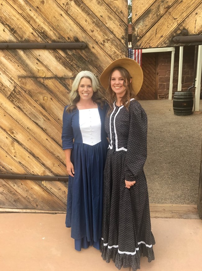 Image Description: Two rangers dressed in pioneer period costume outside the fort doors