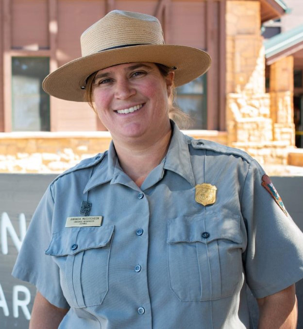 Woman in National Park Service uniform wearing flat hat.