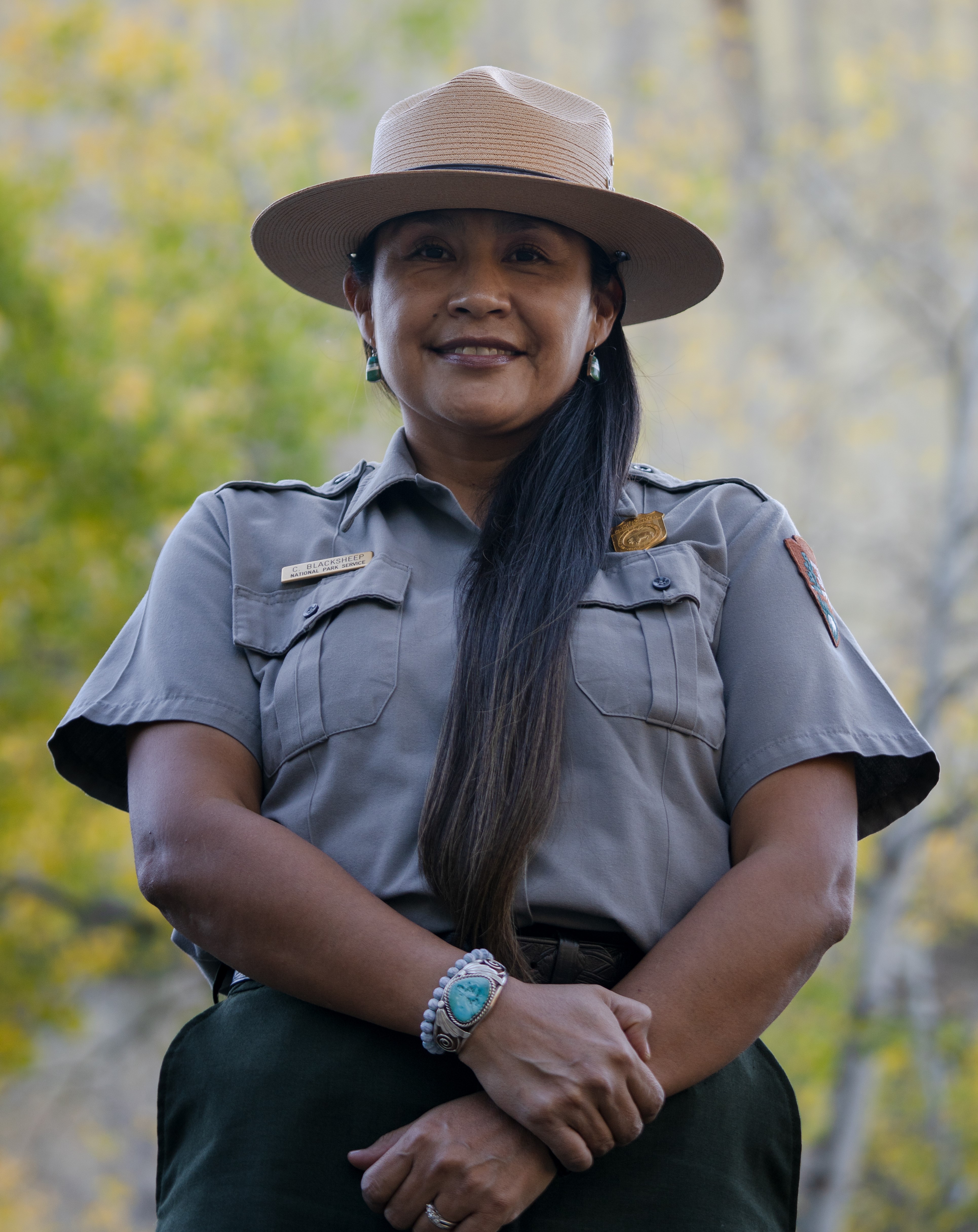 Curlinda Blacksheep Woman in National Park Service uniform wearing a flat hat and a turquoise bracelet