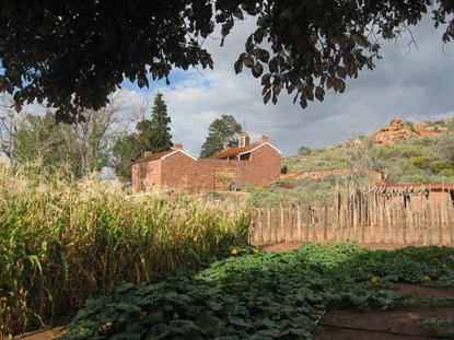 Winsor castle, a stone fort, stands in front of a lush historic garden.