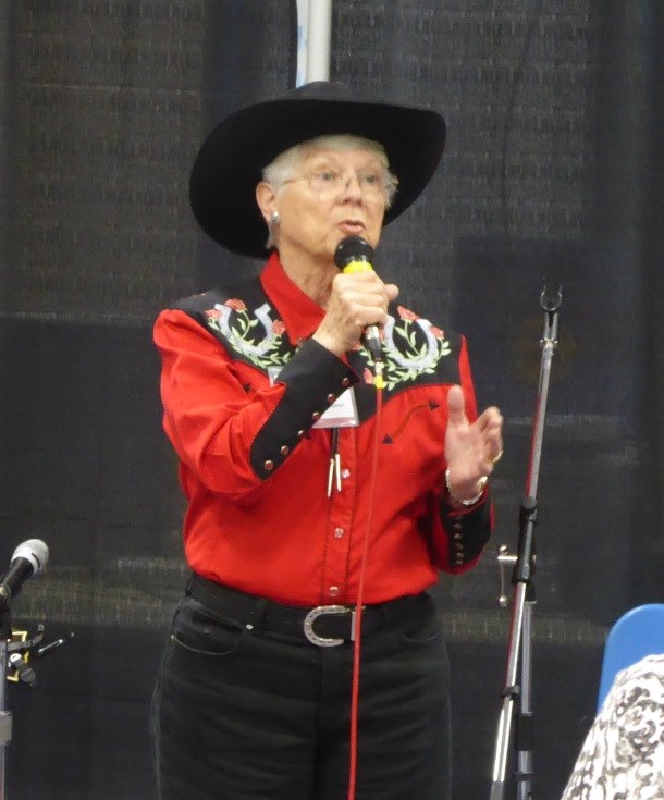 Cowboy Poet Marleen Bussma speaks into a microphone