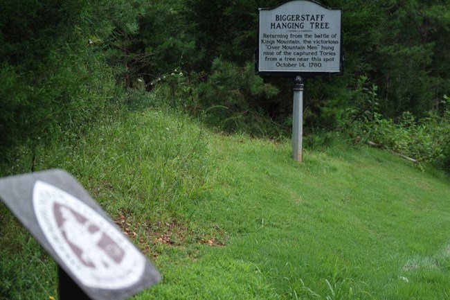 Signs for Biggerstaff Hanging Tree and for the Overmountain Victory National Historic Trail