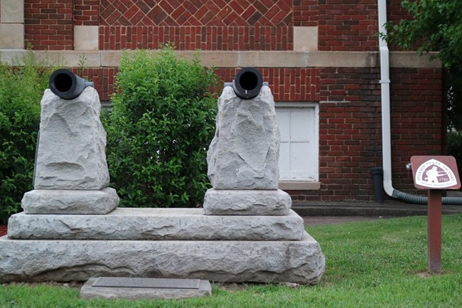 2 small cannons are on stone platforms in front of a flat DAR marker