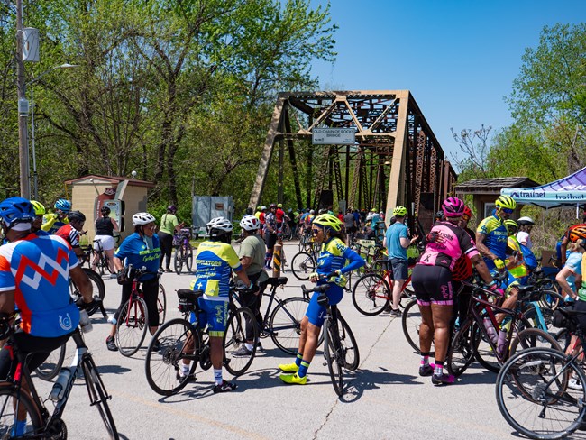 Bikers Standing at Chain of Rocks Park, Missouri Many bikers stand alongside their bikes in front of a large brown bridge