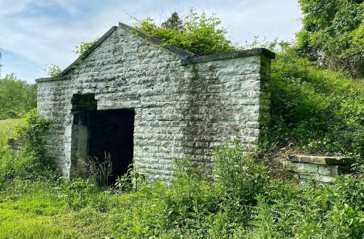 A cemetery vault of mortared cut stone.