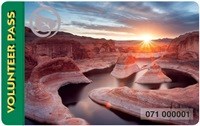 sunburst at sunrise over river flowing through red rock canyon