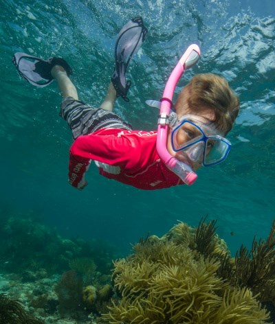 Boy in red shirt snorkeling underwater