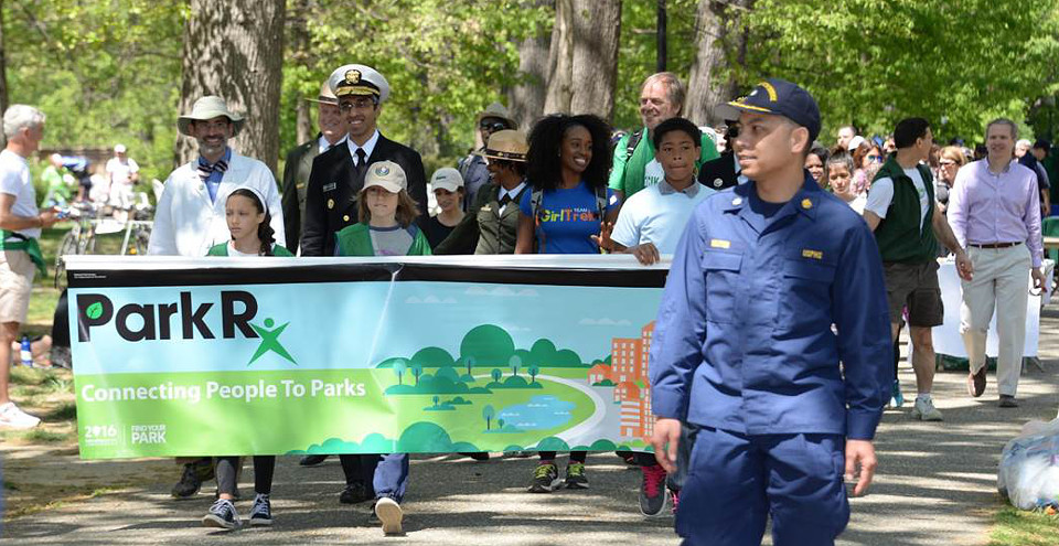 Adults and children marching in a parade