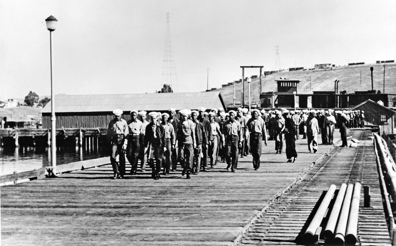Historic photo of African American sailors marching on the pier at Port Chicago.