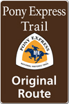 A brown tall rectangular highway sign with white text saying: Pony Express Trail Original Route and a triangular logo with orange and white and a blue pony rider. A brown tall rectangular highway sign with white text saying: Pony Express Trail Original Route and a triangular logo with orange and white and a blue pony rider.