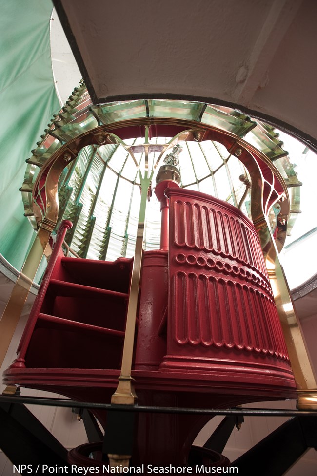 Fresnel Lens at Point Reyes Lighthouse Red stairs leading up into area to change bulb in Fresnel lens at Point Reyes Lighthouse.