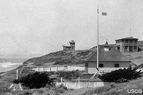 Overview of Point Reyes Naval Radio Compass Station NLG, view to the north. The Point Reyes Life-Saving Station boathouse and flagpole is shown in the foreground. Courtesy of the USCG. On file at Point Reyes National Seashore HPRC#47930.