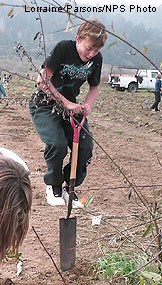 Young boy jumping on shovel.