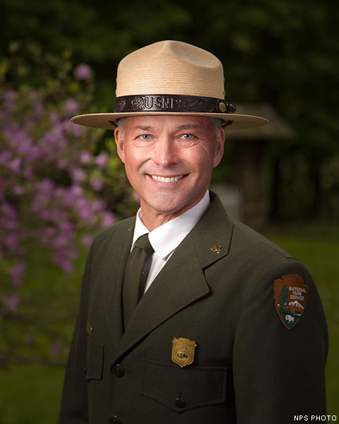 A headshot of a man in a National Park Service dress uniform and flat hat.