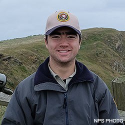 A head photo of Point Reyes Social Media Team member Diego wearing a ball cap and windbreaker.