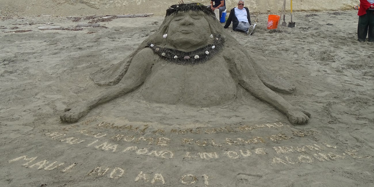 A sand sculpture of the head and upper torso of a Hawai'ian woman wearing a flower crown.