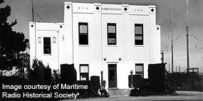 A black and white historic photograph of an art deco-style two story building.