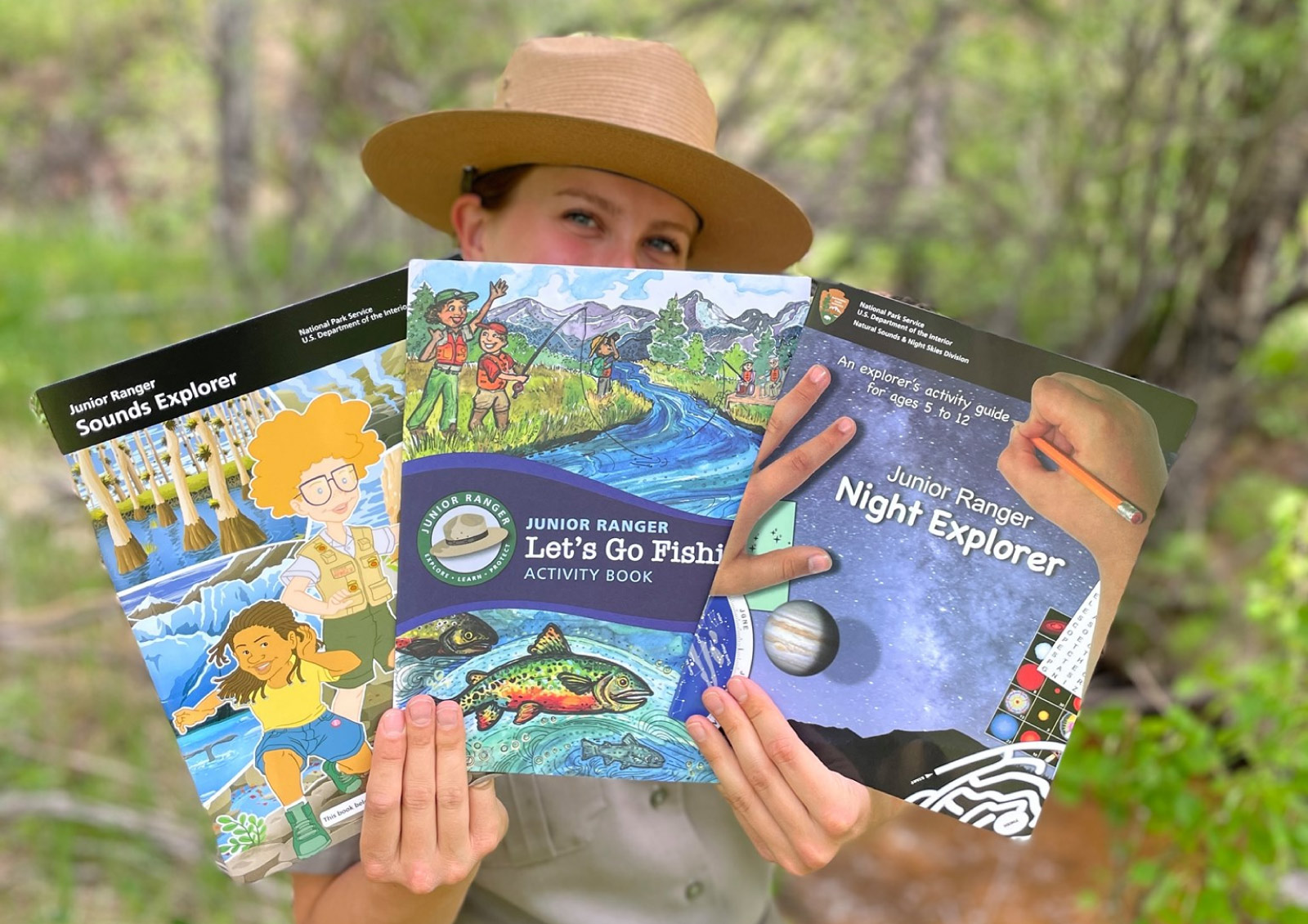 Ranger holds three activity booklets: Night Explorer, Sound Explorer, Junior Angler