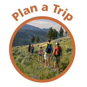 Family hiking through mountains. Text above: Plan a visit.