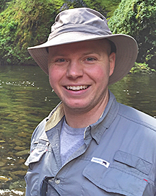 A man wearing a grey shirt and hat