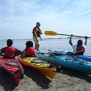 Three people sit in kayaks on the shore at Timucuan Ecological and Historic Preserve Three people sit in kayaks on the shore at Timucuan Ecological and Historic Preserve