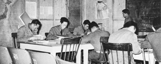 historic photo of Japanese-American soldiers studying at tables