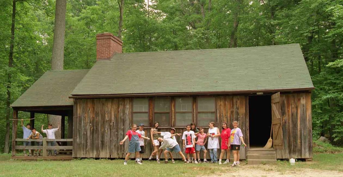 children stand in front of cabin children stand in front of cabin