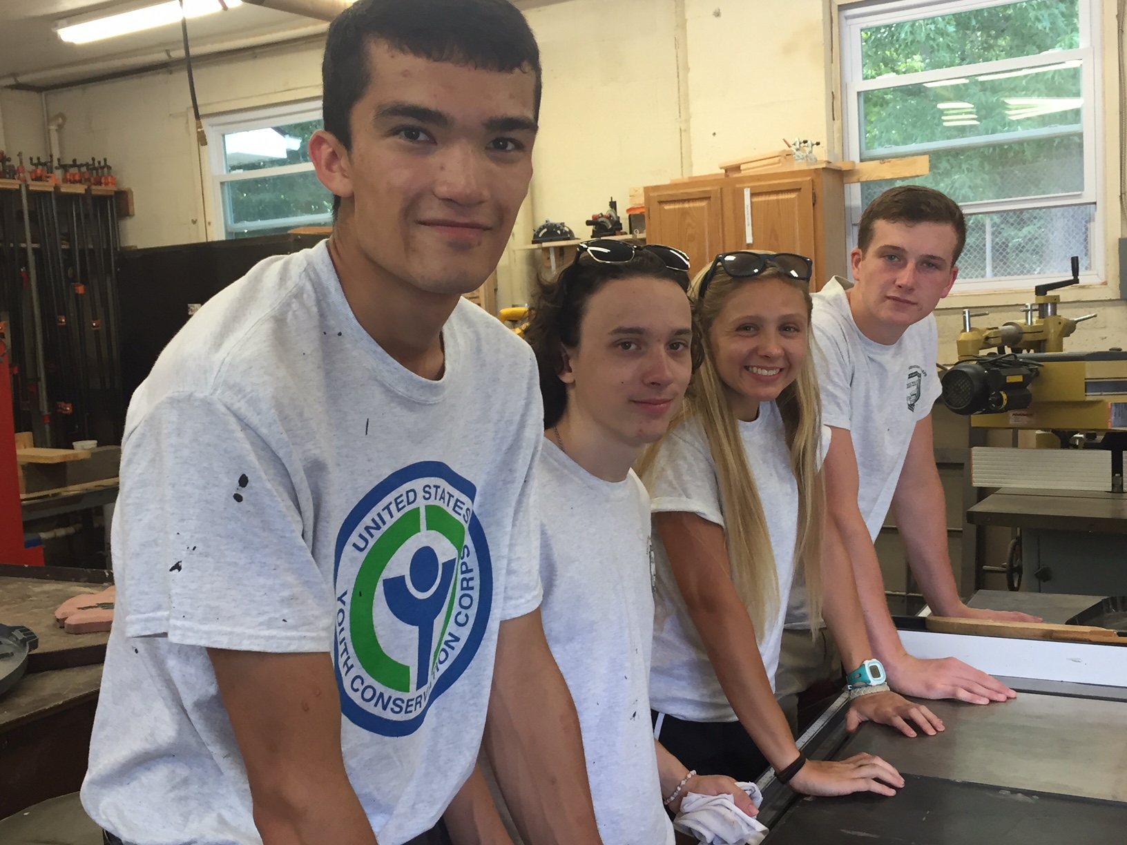 four youth in a workshop pose for a photograph