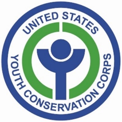 YCC logo. The outer circle is blue. Inside of the circle, curved text reads, "United States" (top) and Youth Conservation Corps (below it)" in blue text in all caps. Inside this text are two green semi circles. Inside of the green semi circles is a small