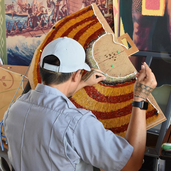 Ranger weaving a feather cape.