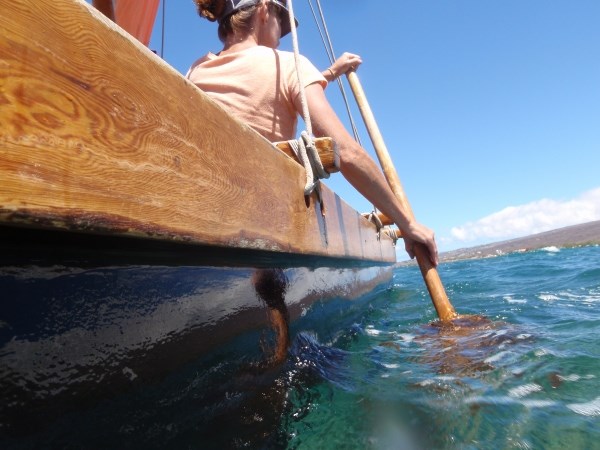 A woman paddles a double-hulled canoe