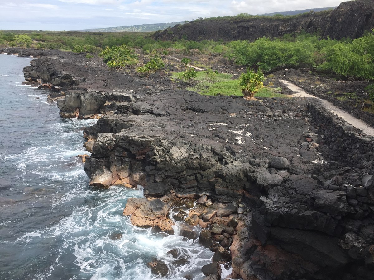 The 1871 Trail winds along the coastal cliffs towards Puʻuhonua o Hōnaunau NHP