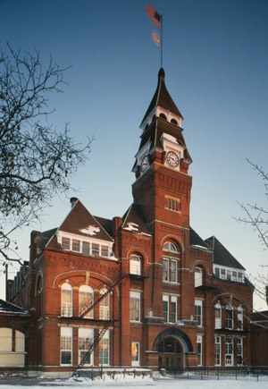 Photo of the Administrative Clock Tower Building with fire escape stairs on the outside and with a twilight sky in the background.