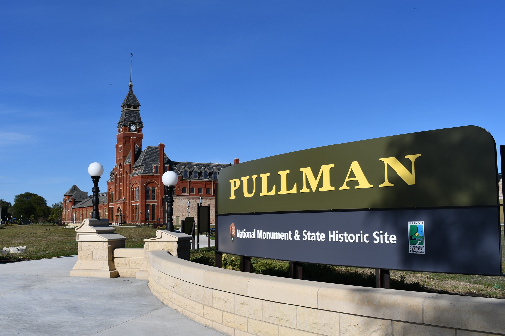 Pullman National Monument and State Historic Site sign in front of the red bricked Administration Clock Tower Building.