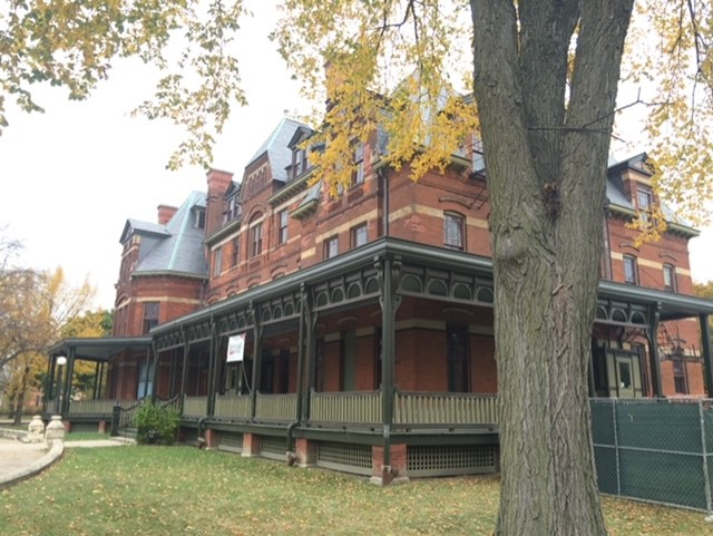 Hotel Florence 2015 A photo of a Victorian four-story tall red brick building. A wrap around green and red porch dominates the first floor view.