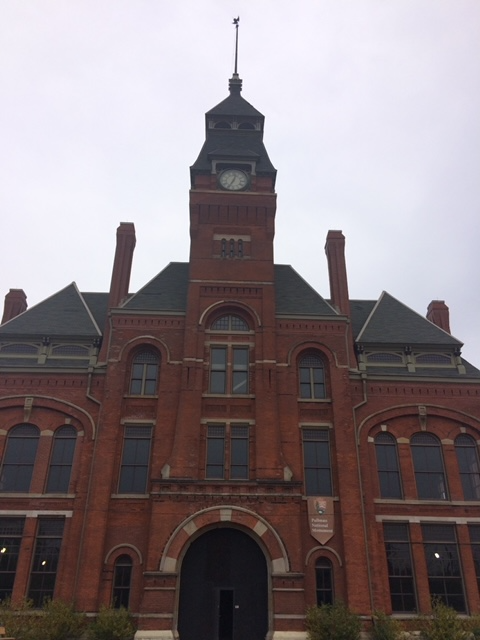 Clock Tower 2015 A photo of the a red brick building with a tall clock tower. On the front hangs a small banner that says "Pullman National Monument".