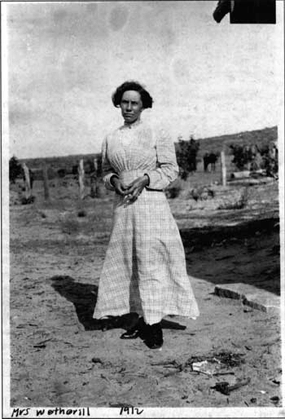 Historic photo of a woman in a white pioneer dress. This is Louisa Wetherill.