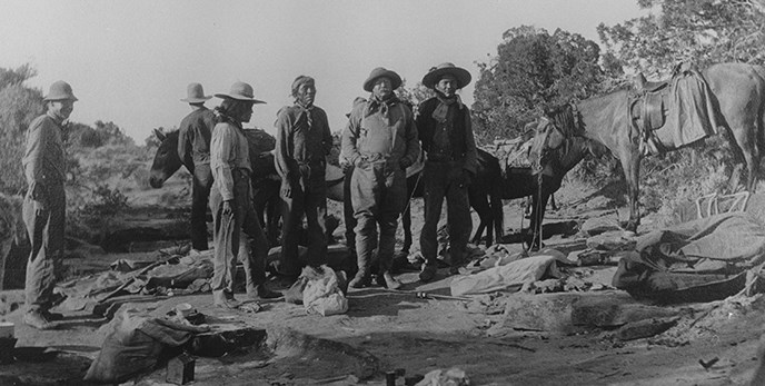 Historic photo of Teddy Roosevelt and party sanding around on slickrock.