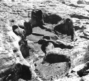 Historic aerial photo of Rainbow Bridge. Cliffs all around.