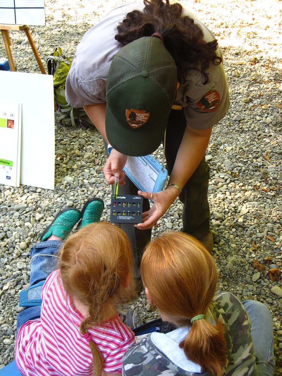 Children and a park ranger work together on a field trip.