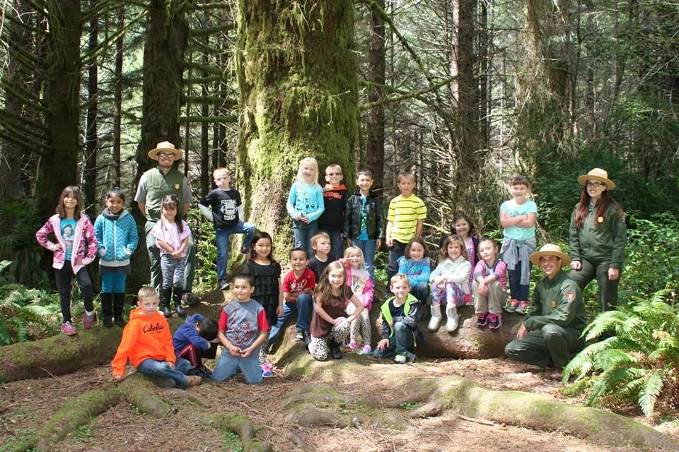 Photo op at Grandfather Spruce Three rangers and class take picture under Grandfather Spruce tree.