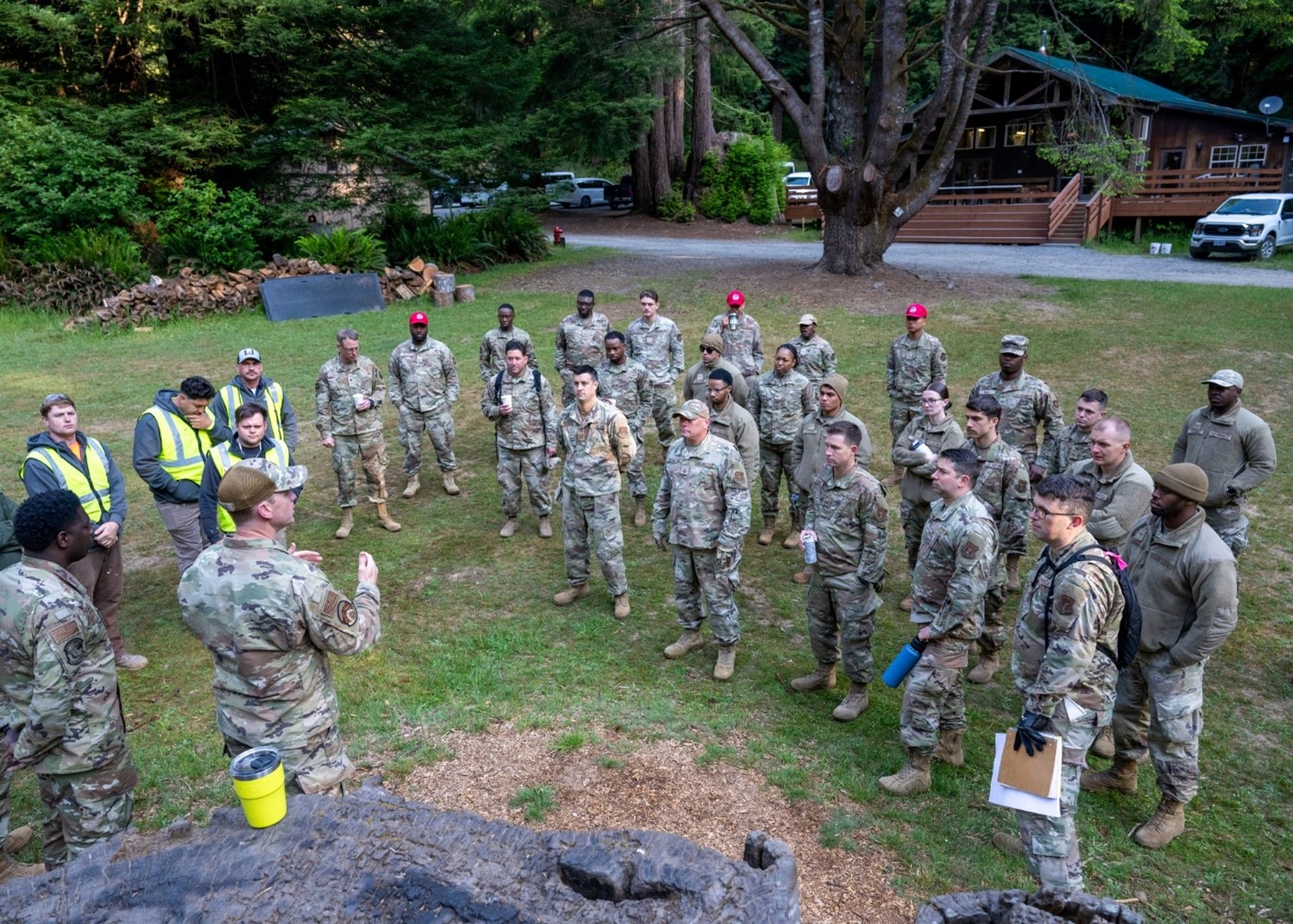 Members of the Air National Guard, Yurok Tribe, and Redwood National and State Parks meet to discuss daily work assignments at Wolf Creek Outdoor School.