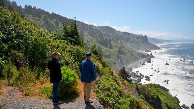 Visitors admiring the rugged, pristine coastline of Redwood National and State Parks.