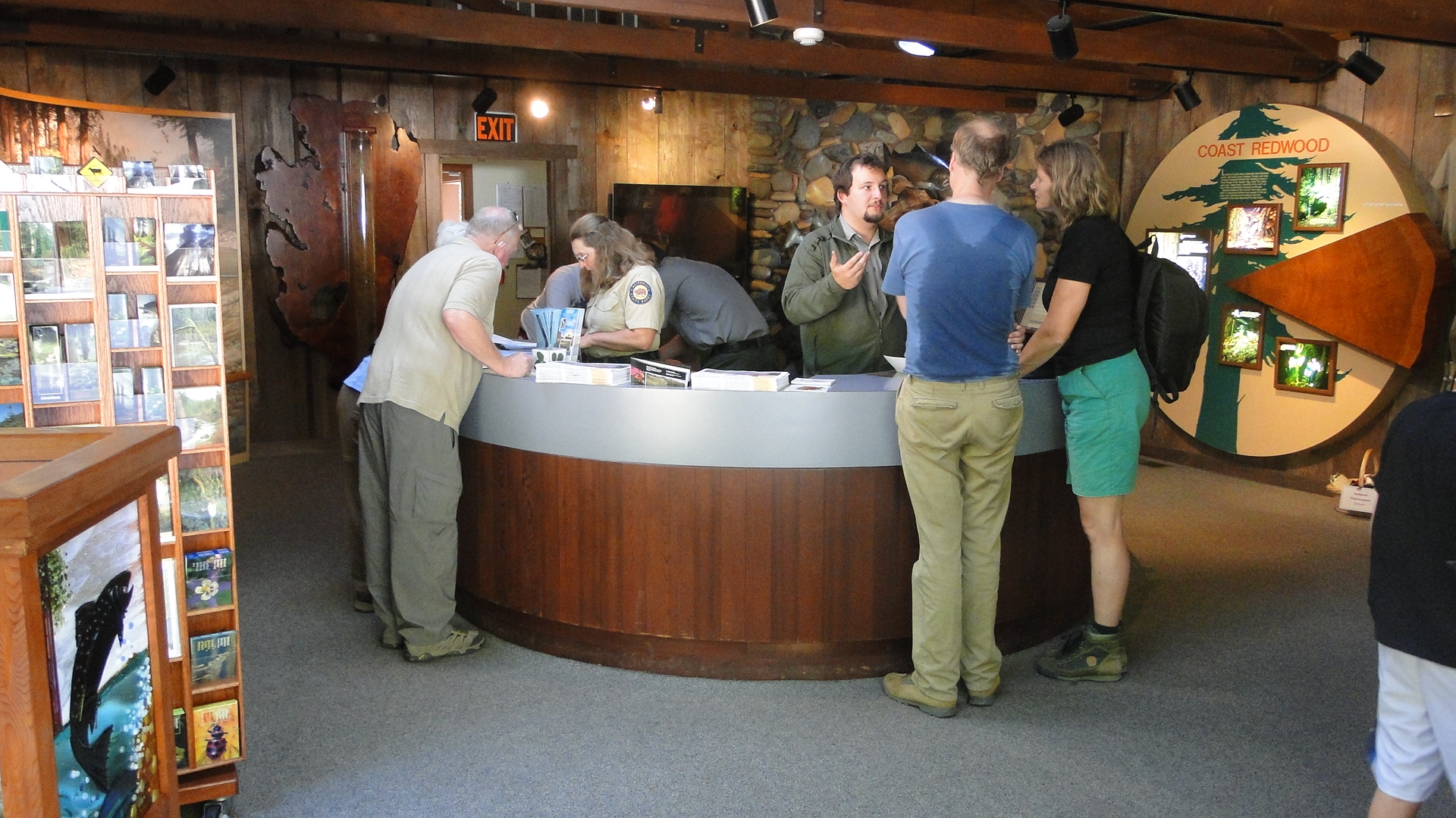 Rangers and volunteers staff a visitor center front desk.