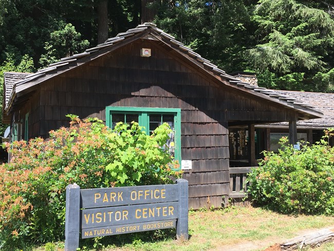 Wooden single story building with a window and wooden entrance sign.